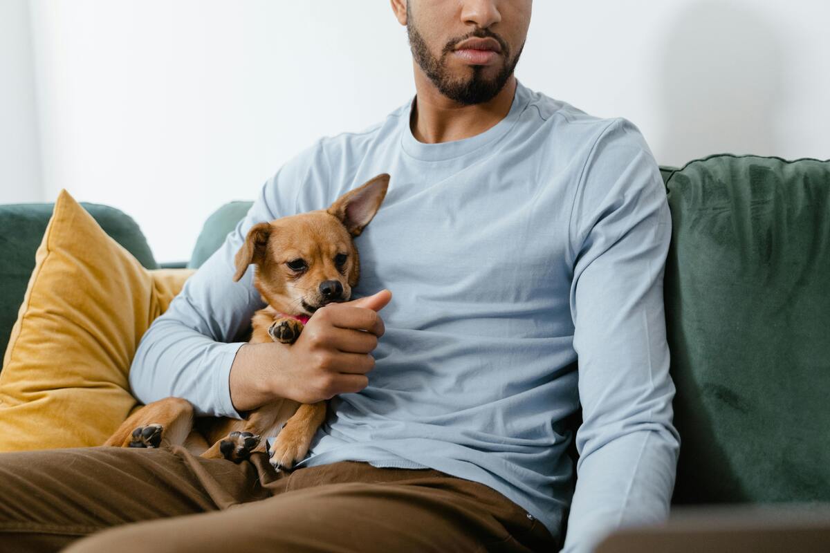 A man cuddling with his dog on the couch